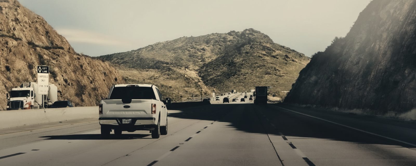 Vehicles on a highway through rocky hills