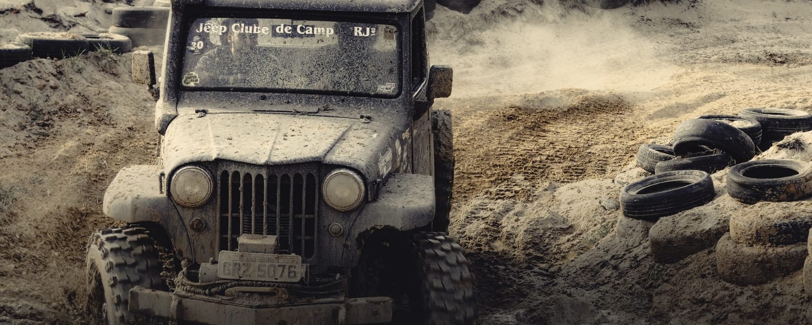 A four-wheel-drive working through a deep muddy track