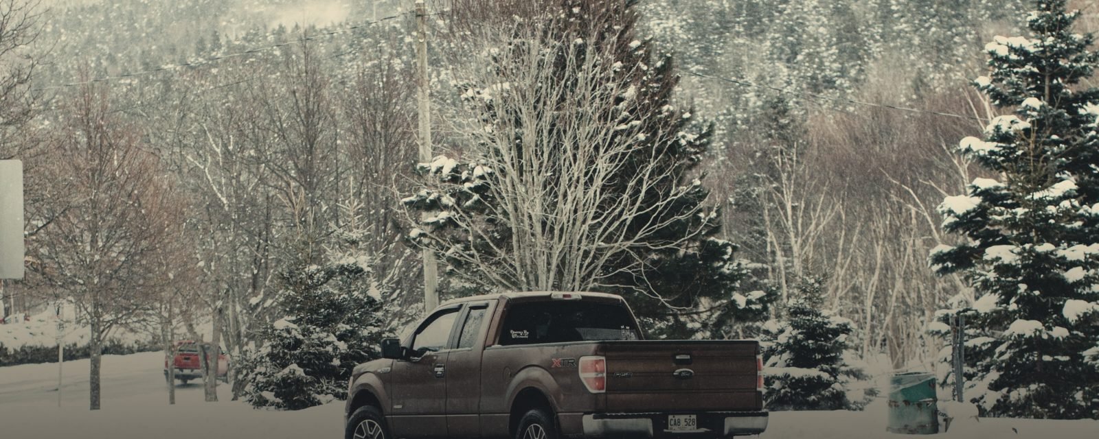 A pickup truck on a snow-covered forest road